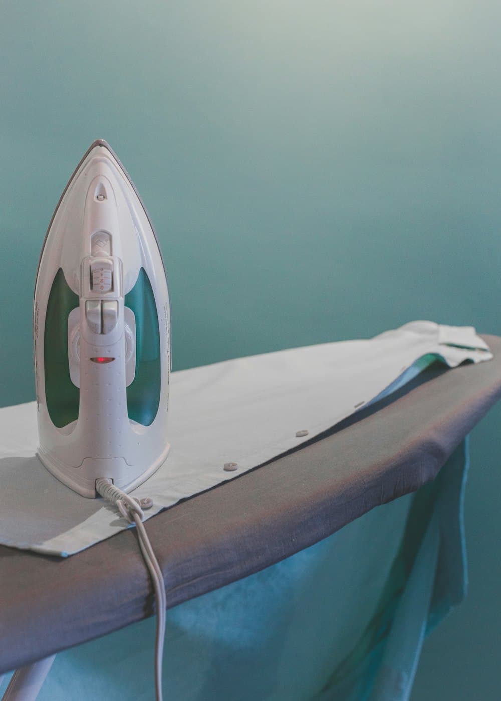 An iron resting on a pressed shirt