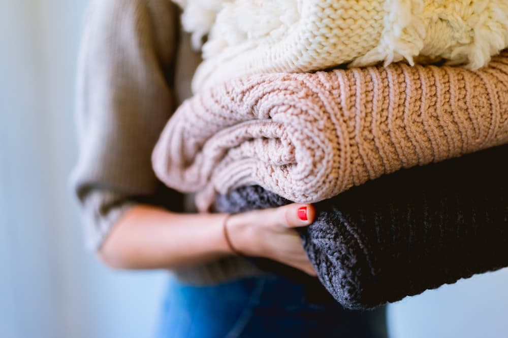 Softly folded knitwear held in both hands